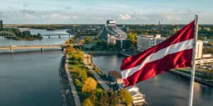 Lettlands flagga, panoramabild över Lettalands huvudstad Riga.